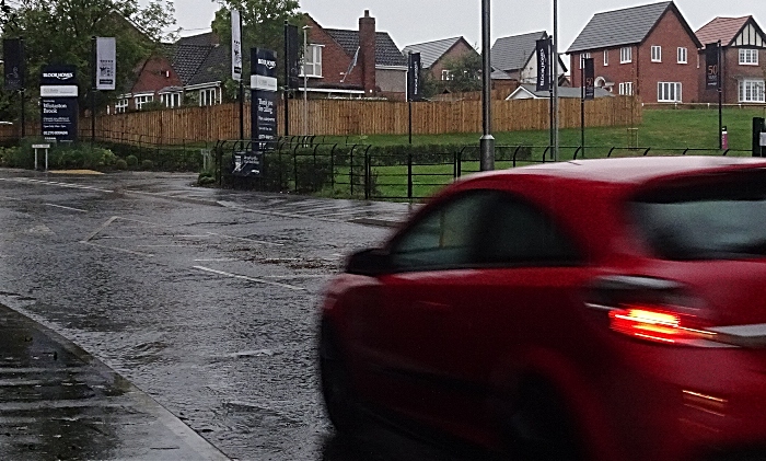 A car passes through standing water on Church Lane opposite Bloor Homes Wistaston Brook housing development in Wistaston (1)