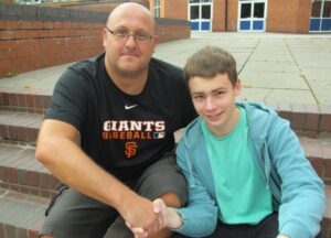 Alex Oultram congratulated by teacher Mr Falamarzi