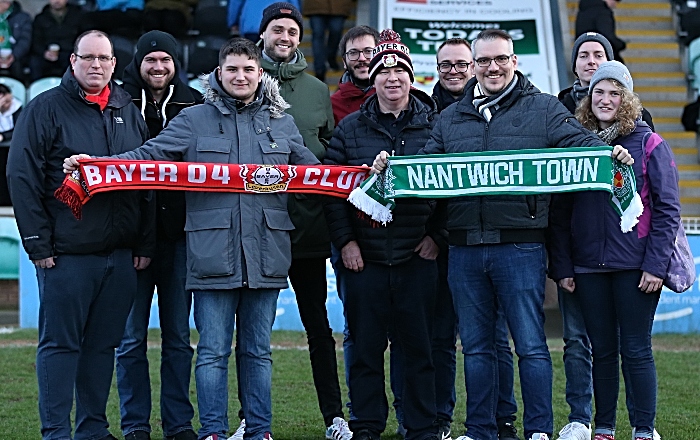 Half-time - Nantwich Town Press Officer Ryan Batty exchanges club scarves with Bayer 04 Leverkusen fans (1)