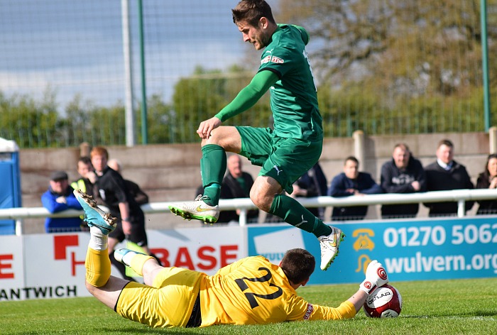 Ilkeston goalkeeper Jamie Hannis stops the challenge from Matt Bell