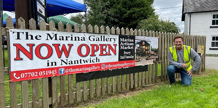 Marina Artisan Market event organiser Harvey with an event publicity sign (1)