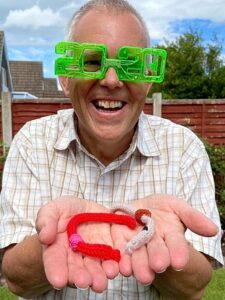 Mark Ray shows off two knitted worms (1)