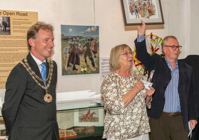 Mayor of Nantwich Town Council, Councillor Andrew Martin looks on as the museum's Molly Stone and Nick Dyer introduce the exhibition raffle