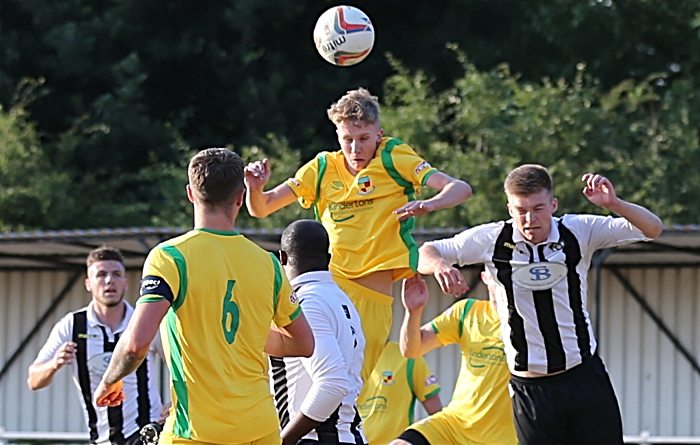 Nantwich player rises the highest to win the ball