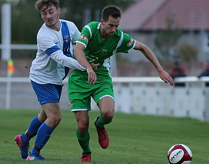 Nathan Cotterall is held back by a Sandbach United player