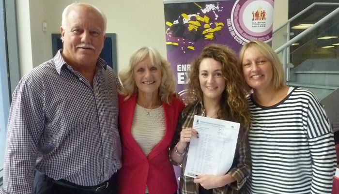 Olivia Moorcroft celebrating her  GCSE results with members of staff and a Governor of Malbank