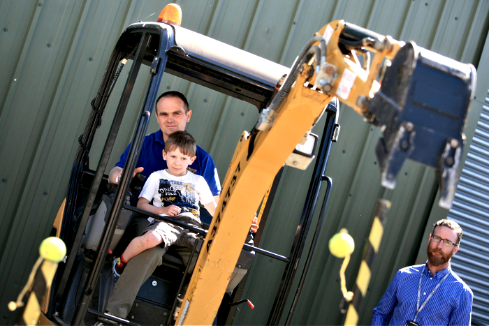 Owen Hughes, 5, and Dad Duncan attempt to knock the tennis balls off, on the digger (1)