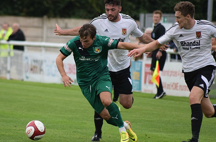 Sean Cooke battles past two Stourbridge defenders