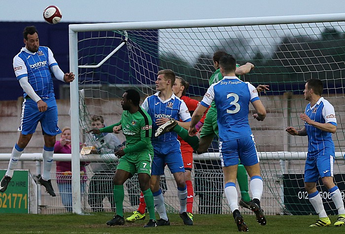 Stalybridge Celtic head the ball clear