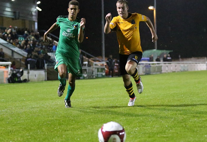 Troy Bourne sprints for the ball with Marine midfielder James Edgar