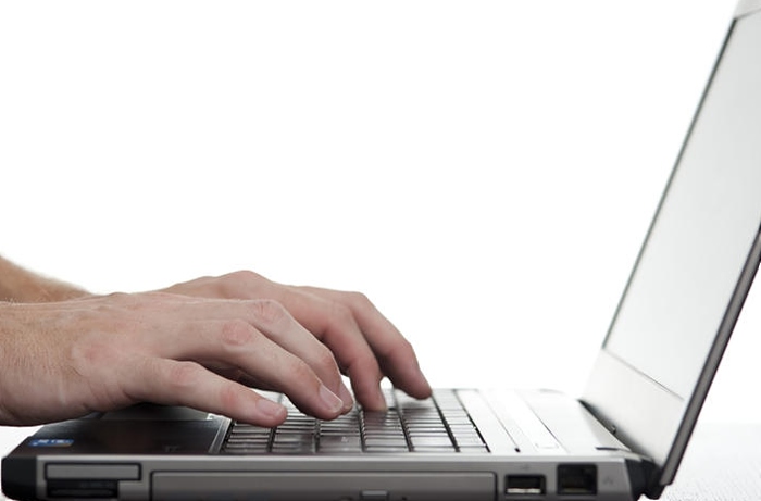 freshman - hands typing laptop keyboard, viewed from the side