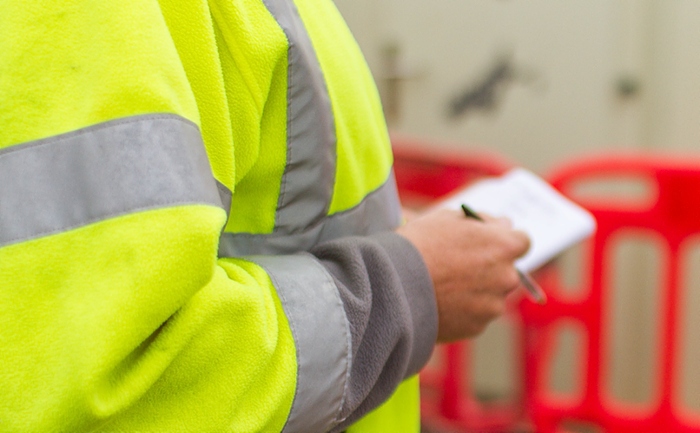 inspector in hi vis making notes